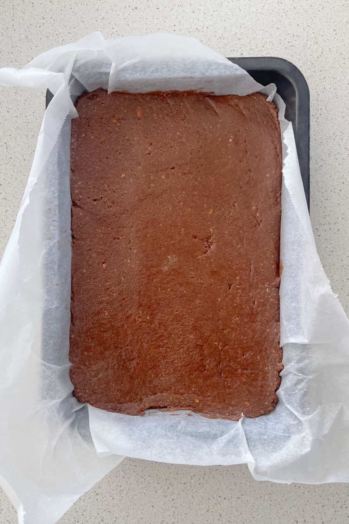 Chocolate Slice pressed down into a baking tray.