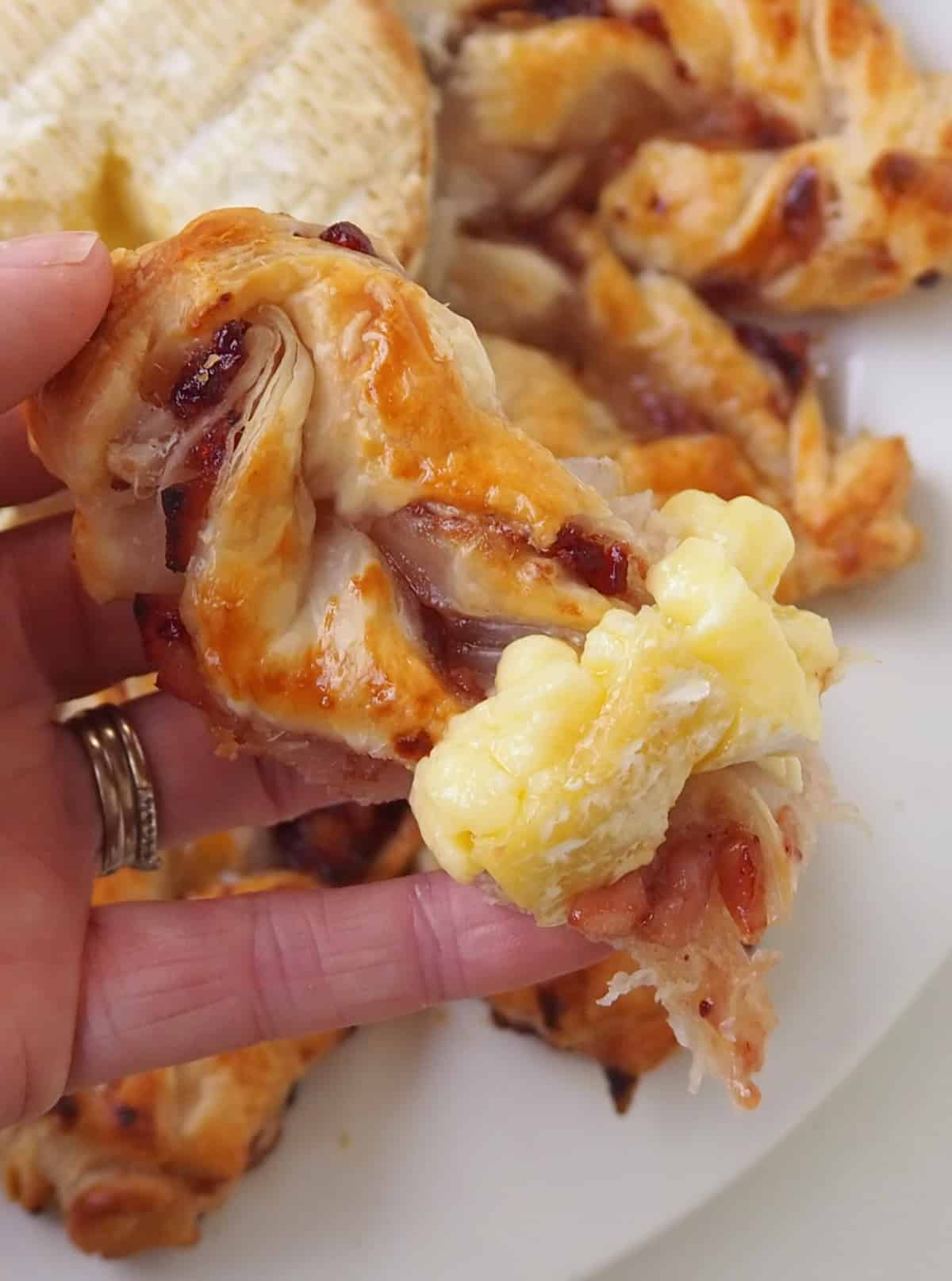 Adult holding a slice of Cranberry and Brie Puff Pastry Star.
