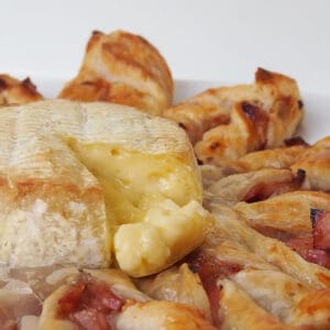 Side view of Cranberry and Brie Puff Pastry Star with a piece of brie removed