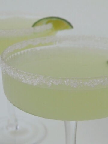 Two Margaritas made using a thermomix in glasses garnished with salt and lime.