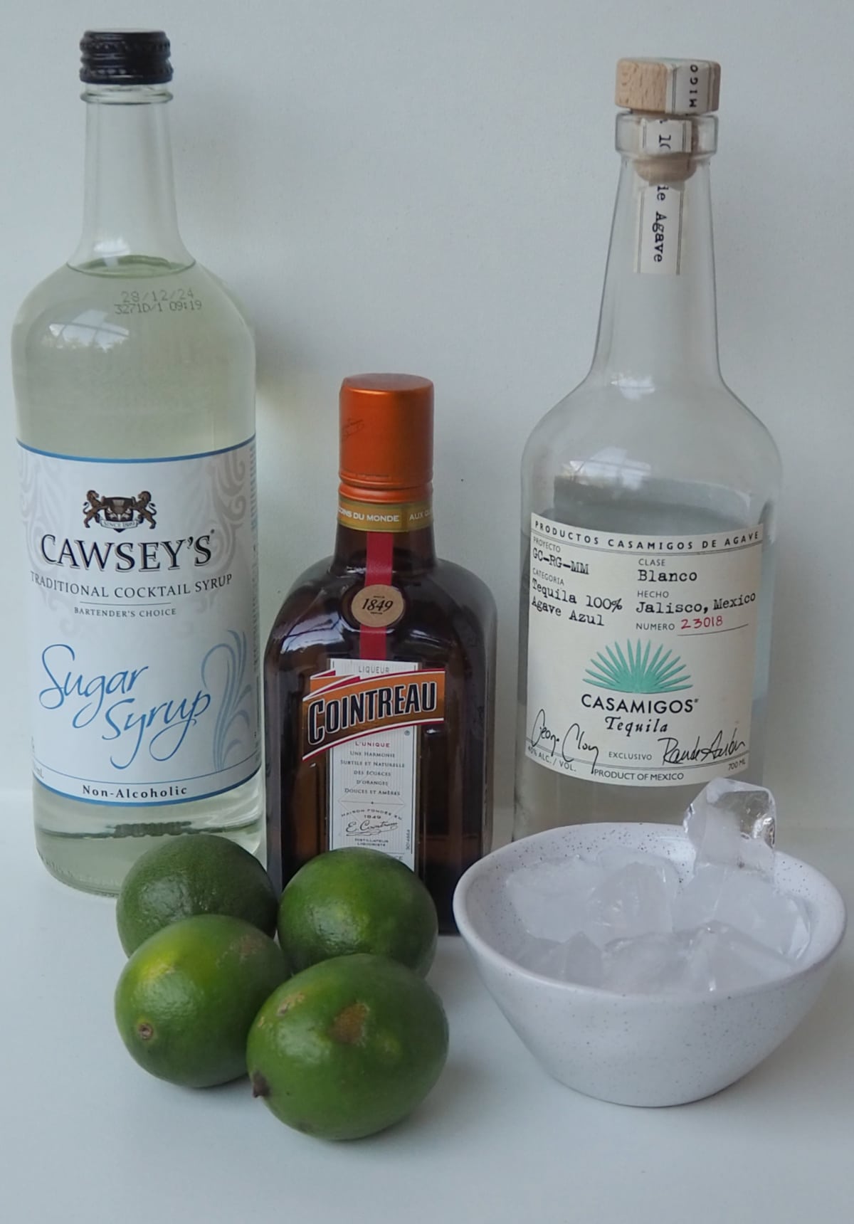 Ingredients to make a margarita on a white bench.