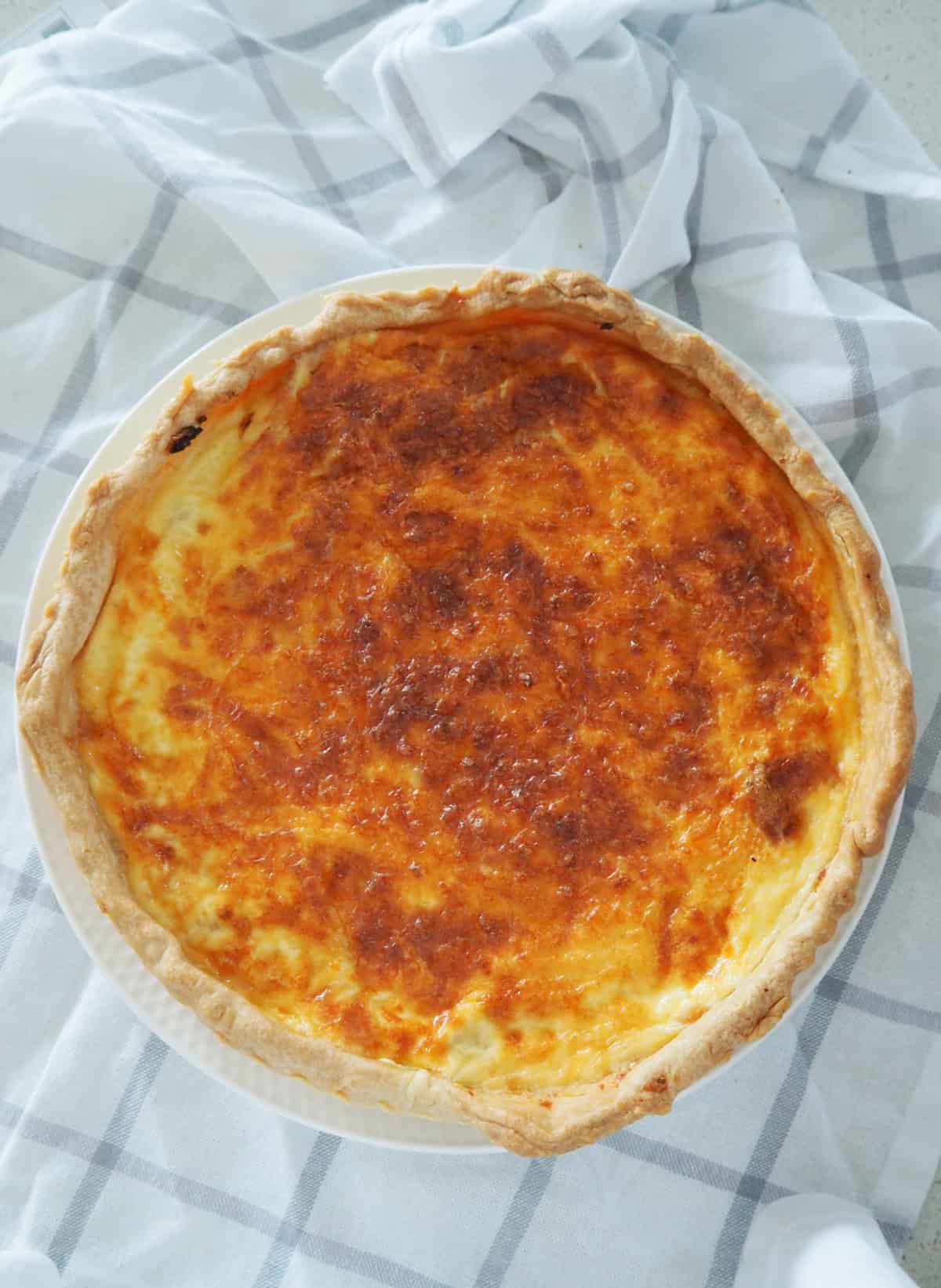 Overhead view of a Quiche Lorraine on a white plate.