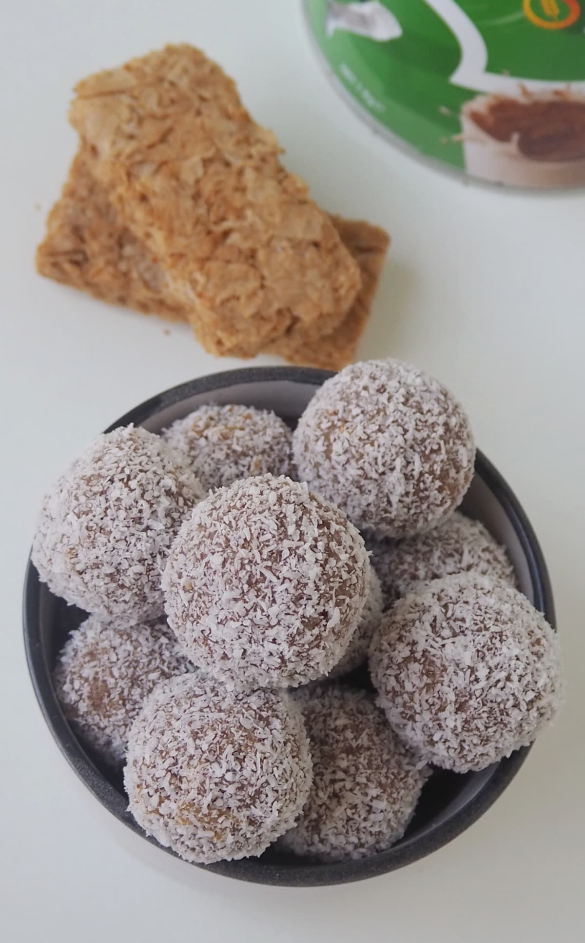 Overhead view of a bowl of Weet-Bix and Milo Balls with a bar of weet-bix in background.