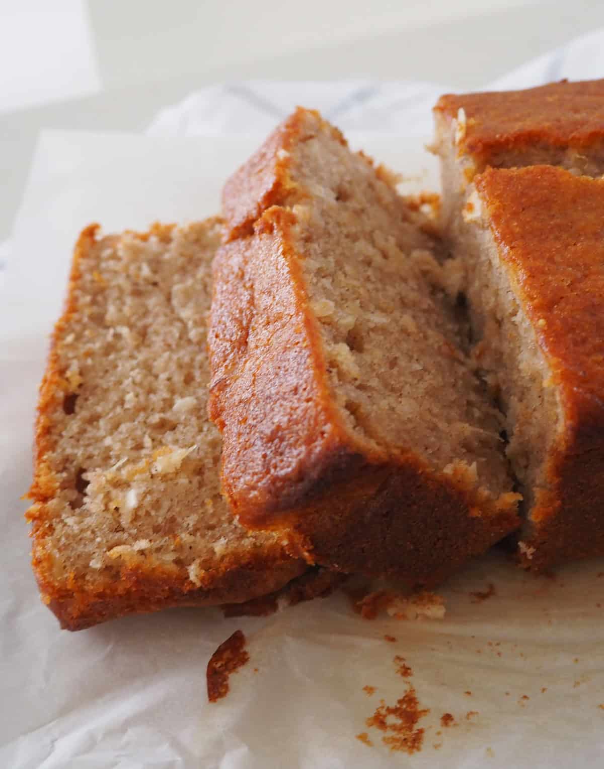 Side view of sliced Banana and Pineapple Cake on a piece of baking paper.