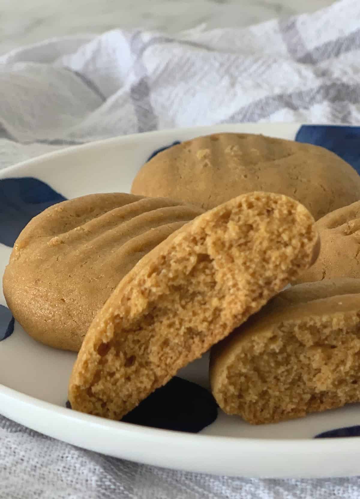 Side view of a caramel biscuit broken in half on a plate.