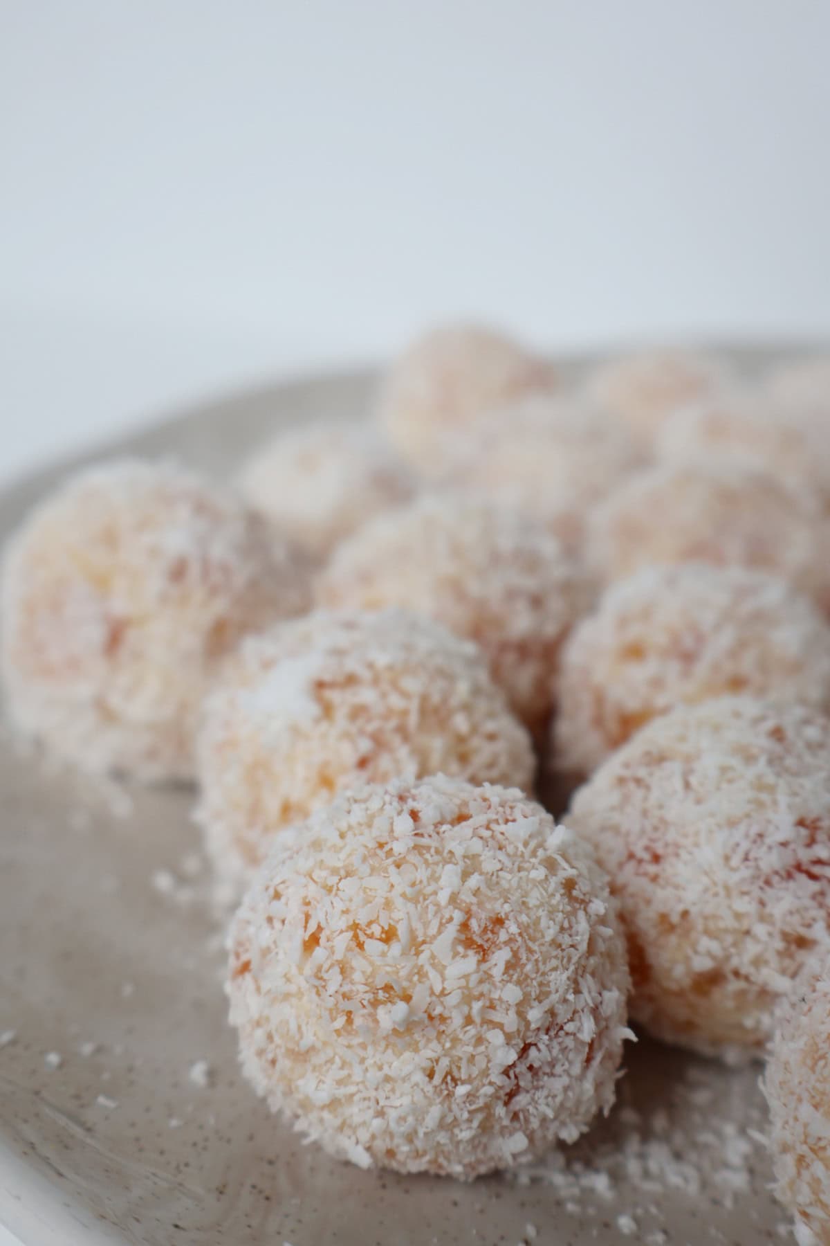 Side view of a close up of apricot and coconut balls.