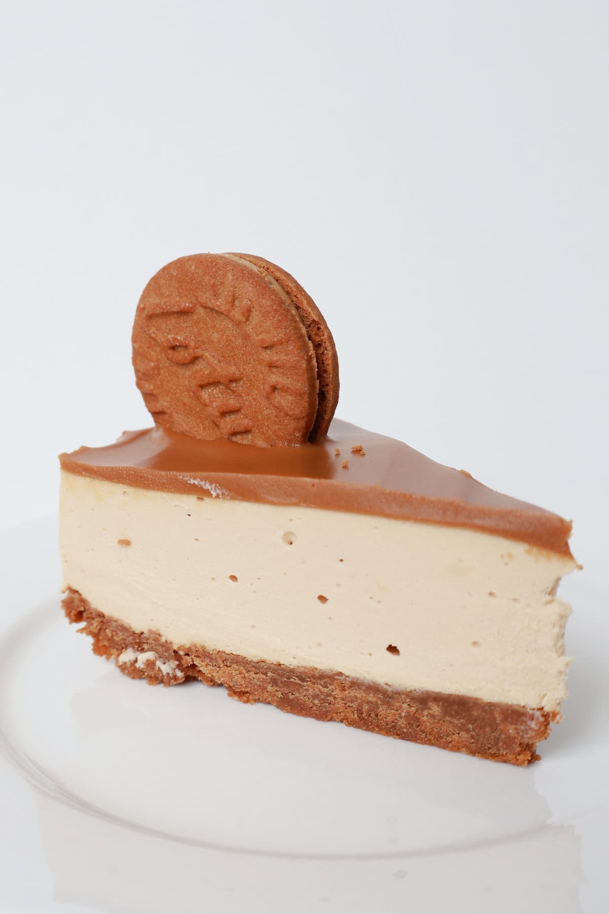 Piece of Biscoff cheesecake on a white plate.