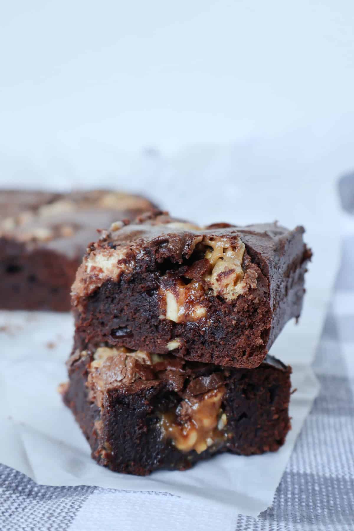 Two Chocolate Snickers Brownies sitting on top of each other. 