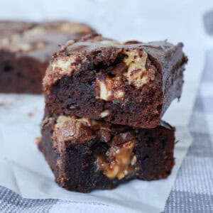 Two Chocolate Snickers Brownies sitting on top of each other.