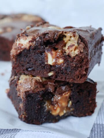 Two Chocolate Snickers Brownies sitting on top of each other.