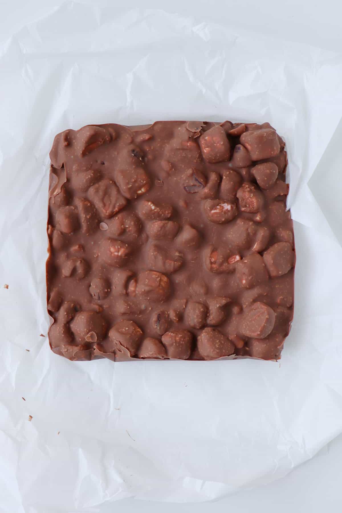 Chocolate Rocky Road removed from the fridge and sitting on a piece of baking paper.