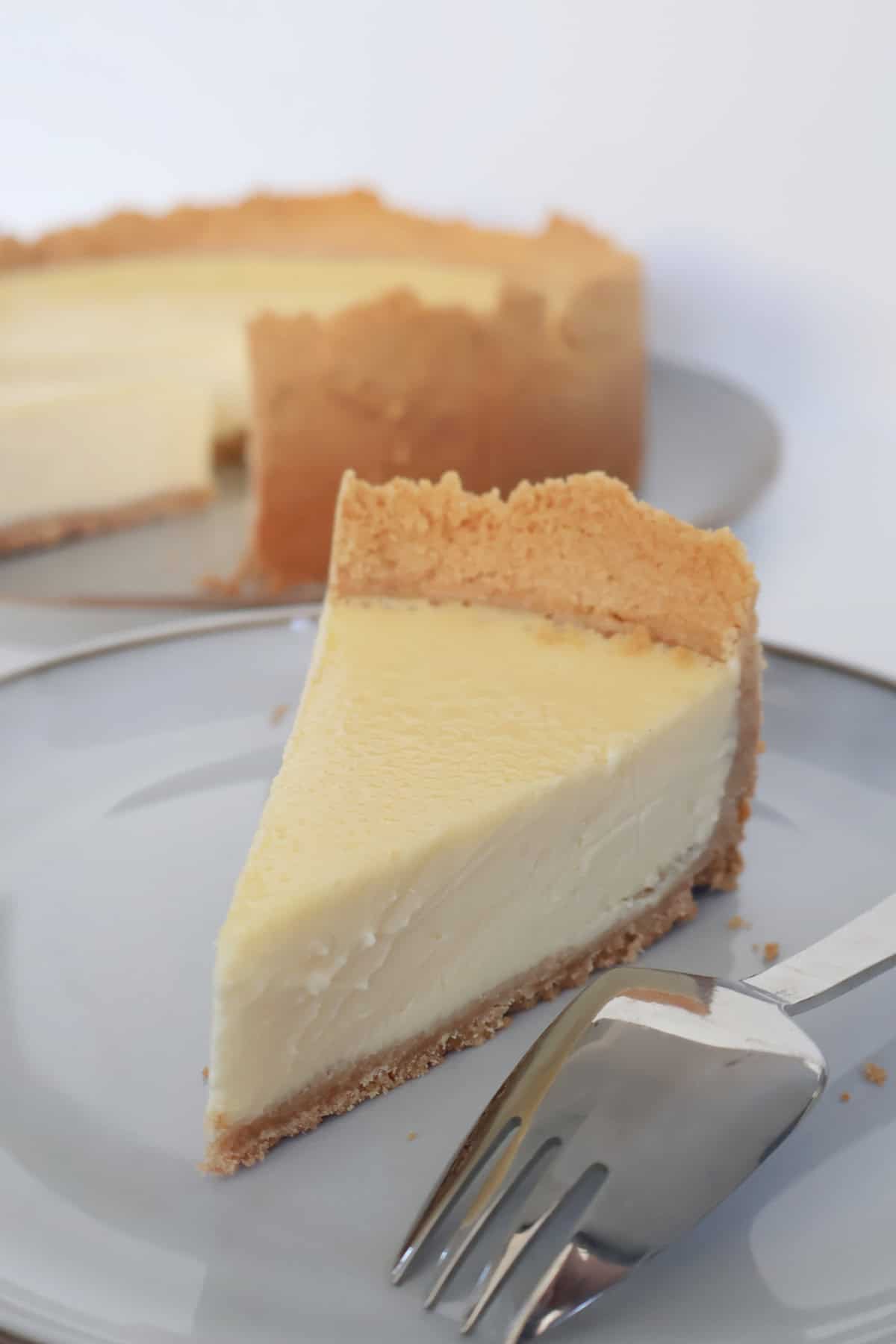 Slice of baked lemon cheesecake on a plate.