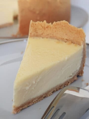 Slice of baked lemon cheesecake on a plate.